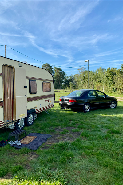 Unser Wohnwagen samt unserem Auto ist zu sehen. Wir haben gerade eingeparkt und uns eingerichtet auf unserem Platz.