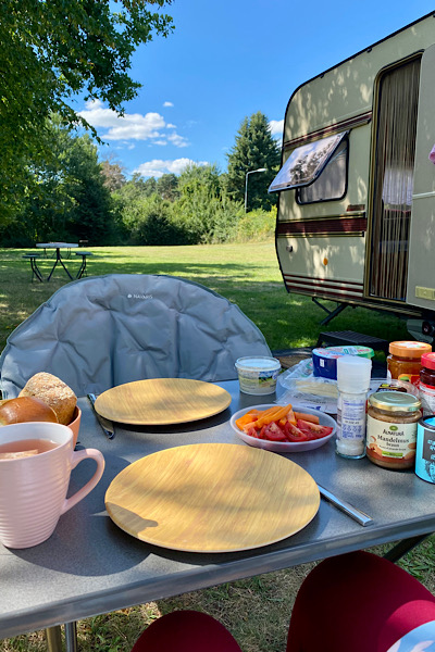 Frühstück draußen vor unserem Wohnwagen auf dem Campingplatz. Wir sind hier ganz allein.