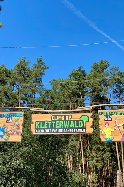 Am Rand des Erlebnishofs Klaistow ist ein großes Waldstück. Hier sieht man das Eingangsschild zum Kletterwald.