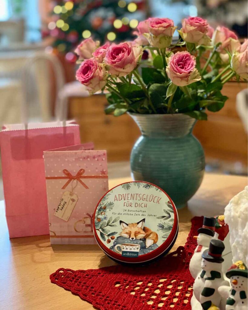Mein Geburtstagsstrauß aus rosafarbenen Rosen, eine rosa Geschenktüte, eine rosa Geburtstagskarte und eine Schachtel mit einem Adventskalender stehen auf meinem Tisch. Ich liebe rosa!