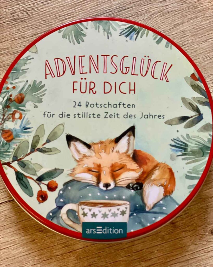 Hier sieht man in groß die runde Schachtel mit meinem Adventskalender: "Adventsglück für dich - 24 Botschaften für die stillste Zeit des Jahres".