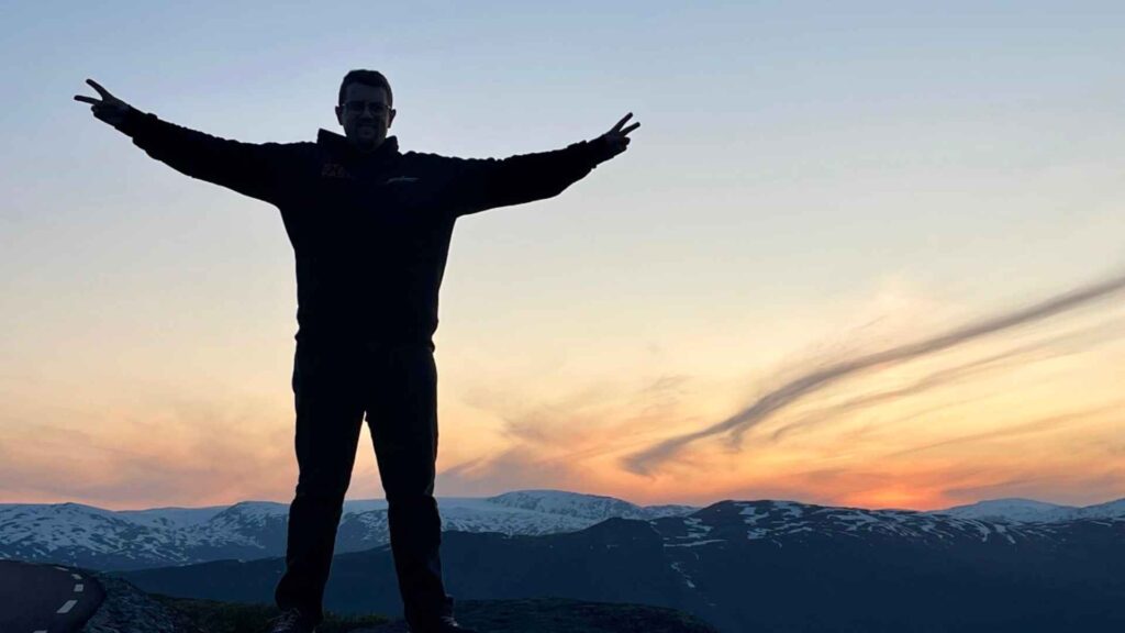 Mein ältester Sohn steht mit ausgebreiteten Armen am Nordkap und genießt die grandiose Aussicht, die noch getoppt wird von einem wunderschönen Sonnenuntergang.